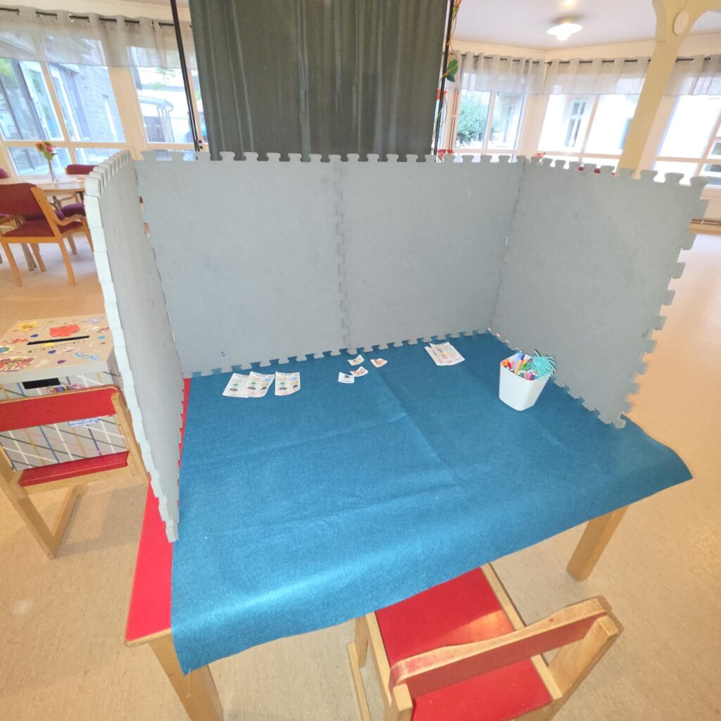 AvskÀrmad röstningsplats med valsedlar och fÀrgpennor.